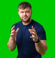 A man gestures with enthusiasm in front of a bright green background photo