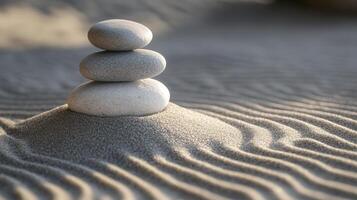 A serene arrangement of three stones resting atop a sand mound with gentle ripples, showcasing tranquility in a natural setting photo