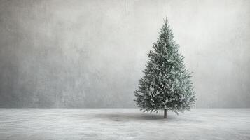 A snowy Christmas tree stands alone in a minimalist setting with a textured gray wall and floor, capturing a serene holiday atmosphere photo