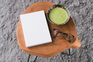 blank book cover mockup on coffee table with green matcha tea photo