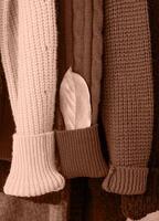Mocha Mousse - color of the year 2025. Row of different colorful Knitted sweaters hang on hangers photo