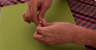 Hands prepare twines and make knot for hanging of Christmas ornaments. Christmas DIY craft project with easy-to-follow steps and materials video