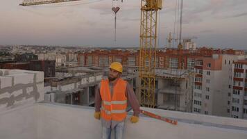 Construction worker pointing upwards at building site with cranes and cityscape video