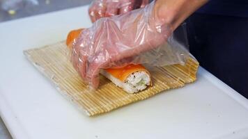 Chef hands preparing japanese food. Close up view of preparation of sushi roll in restaurant video