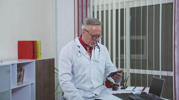 Doctor speaks with patient. Doctor with stethoscope in surgery office talking to patient online video