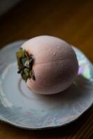 Frozen persimmon on a saucer. Persimmon covered with frost photo
