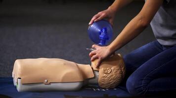 Resuscitation during first aid training. First aid instructor showing resuscitation technique on dummy video