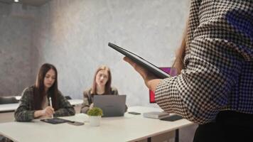 Modern and up-to-date teacher delivers lecture using latest technologies, including digital tablet, to young university students. video