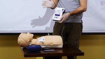 Man teaching cardiopulmonary resuscitation. First aid cardiopulmonary resuscitation course using automated external defibrillator device video