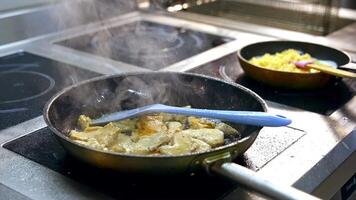 Frying food on iron pan. Chef cooking food in large pan at restaurant video