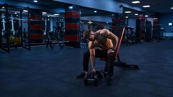 Bodybuilder working out with dumbbell. Young muscular man doing hard exercise with dumbbells video