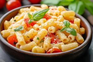 Pasta with cherry tomatoes, basil, and grated cheese being served in a bowl photo