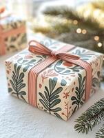 Christmas gift wrapped with floral paper lying on snow with fir branches and lights in the background photo