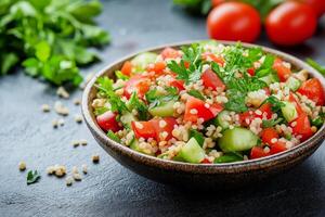 Tabbouleh salad with tomatoes, cucumbers, and parsley in a wooden bowl photo
