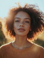 Young woman with freckles and afro hair posing in sunlight photo