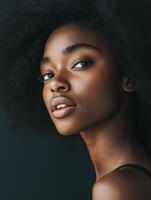 Portrait of confident young woman with afro hairstyle on dark background photo