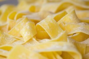 Fresh pappardelle pasta forming appealing ribbons with flour dusting photo