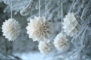 Paper flowers hanging from a tree in the snow photo