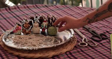 Hand put recycled clay ball at tray for Christmas craft project with natural materials and basic tools. Gather supplies like pinecones, string, and decorations to create festive ornaments. video