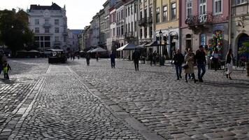 Lviv, Ukraine - 10 09 2020. Time lapse of walking people at crowded Market square of old town. Tourists walk by ancient cobblestone pavement at Rynok square. Downtown of Europe city video