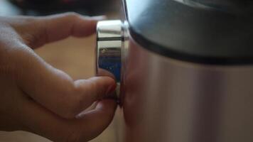 A hand is making an adjustment to the dial on a modern kitchen appliance video