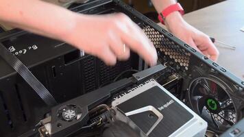 Hands with screwdriver assemble CPU cooler and NVidia GeForce RTX 3080 graphics card in PC. Then check power supply cable plugs before connecting into GPU. Mining hardware. Odessa, Ukraine, 04 07 2021 video