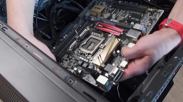 Male hands connect cables and carefully place motherboard with copper heat exchanger into PC case Zalman. Computer hardware assembling for mining and gaming. Odessa, Ukraine, 04 11 2021 video
