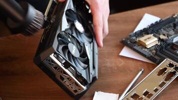 Man hand holds vacuum cleaner pipe with brush and vacuuming dust at NVidia GeForce RTX 3080 graphics card for gaming PC and mining of cryptocurrency. Hardware maintenance. Odessa, Ukraine, 04 14 2021 video