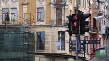 Red light and green light of pedestrian traffic light with urban background of tourist signs and security cameras. Countdown display of traffic light in old town of Lviv, Ukraine, 10 06 2020 video