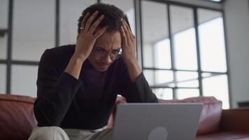 homem voltado para financeiro problema enquanto usando computador portátil segurando crédito cartão video