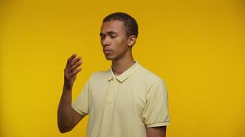 Tired Young Man Wiping Forehead Against Yellow Background video