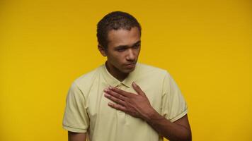 Unwell man with hand on chest experiencing discomfort on yellow video