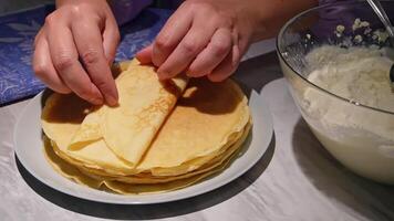 Making crepes by hand with fresh batter on a kitchen counter video