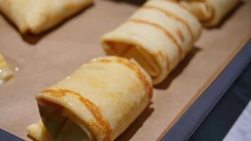 Freshly baked pancake rolls on baking tray with golden brown crust video