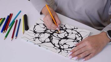 Hands coloring intricate patterns with various pencils in relaxing creative process video