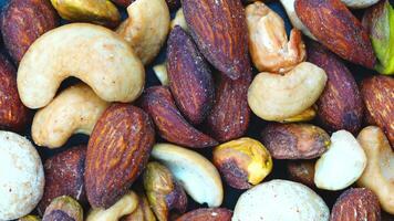 Top view rotation of dry salted mixed nuts, closeup, horizontal, background. video