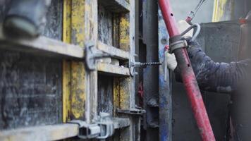Worker adjusting formwork connection with hammer video