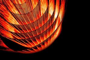 Abstract spiral with glowing red and orange tones and wire texture against a black background, symbolizing energy, motion, industrial and futuristic design concepts. Copy space photo