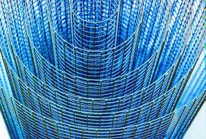 Abstract spiral metal coiled wire mesh with blue grid pattern, geometric symmetry, minimalist design for industrial construction, diy, architectural concepts. Isolated on white background. Copy space photo