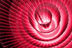 Abstract spiral with glowing pink purple wire texture against a black background, symbolizing color contrast, energy, motion, industrial and futuristic design concepts. Copy space photo