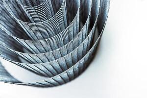 Abstract spiral metal coiled wire mesh with grid pattern, geometric symmetry, modern minimal design for industrial construction, diy, architectural concepts. Isolated on white background. Copy space photo