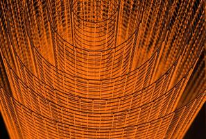 Abstract spiral with glowing red and orange tones and wire texture against a black background, symbolizing energy, motion, industrial and futuristic design concepts. Copy space photo
