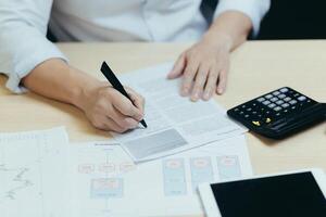 A close-up photo of a businessman's hand working on paperwork, an accountant, a financier, calculates financial statements and sums them up on a calculator