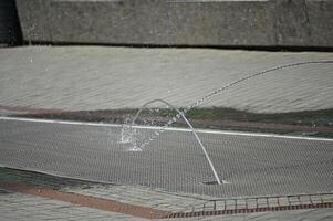 a man is playing with a water fountain photo