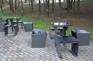 a group of metal benches and tables in a park photo
