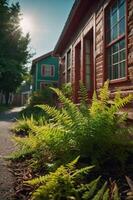 A vibrant fern grows beside a charming alleyway with colorful houses in the background. photo