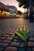 A serene street scene at dusk, featuring a leaf on cobblestones and colorful buildings. photo