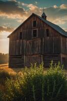 A rustic wooden barn at sunset, surrounded by tall grass and a serene landscape. photo