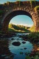 A serene view of a stone bridge arching over a tranquil stream surrounded by lush greenery. photo