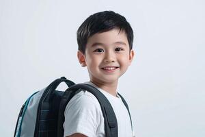 A young boy with a backpack smiling photo